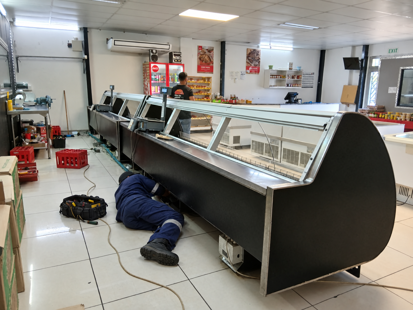 Swiftech technician repairing a commercial refrigerated display counter